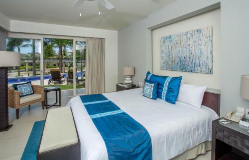 a bedroom with a large bed with blue pillows at Marival Distinct All-Suites & World Spa - Handwritten Collection in Nuevo Vallarta 