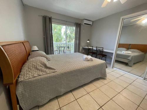 1 dormitorio con cama y espejo grande en 28 - Jordan Village beautiful studio - Résidence Palm Court, en Cul de Sac