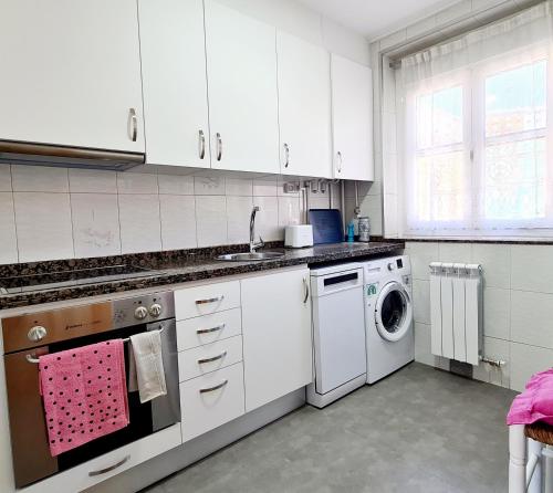 a kitchen with white cabinets and a washing machine at VEGA DEL CARMEN in Teruel