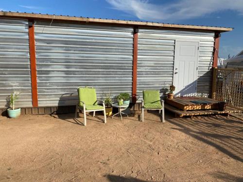 two chairs and a table in front of a garage at Cerrado in El Porvenir