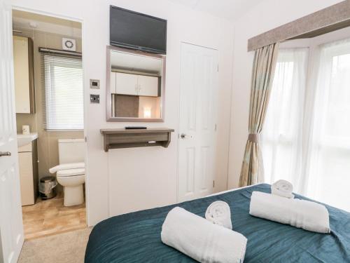 a bedroom with a bed with a television and a toilet at Number 10 in Carnforth