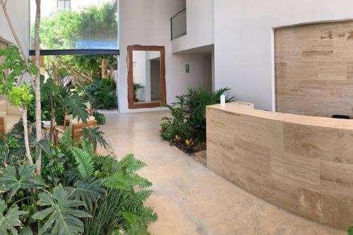 a hallway of a building with plants at KAAB South Beach - Beautiful Big Studio - Rooftop pool ocean view in Playa del Carmen