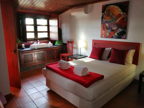 a bedroom with a bed and a bathroom with a tub at Casa De Campo Colmeal in Mira