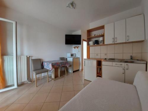 a kitchen with white cabinets and a table in a room at Apartment Pezić in Krk