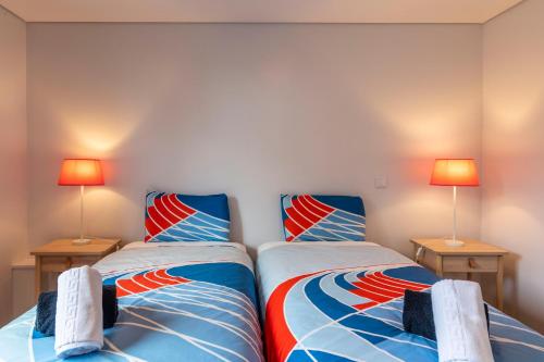 2 camas individuales en un dormitorio con 2 lámparas en Your Azorean Home RRAL 3378, en Ribeira Grande