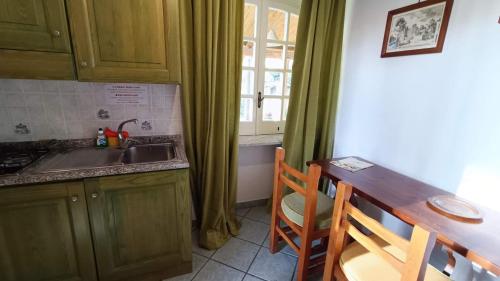 a kitchen with green cabinets and a sink and a table at Residence Villa Cristina in Ischia