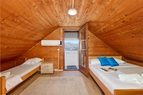 a bedroom with two beds in a wooden cabin at Vukićević House in Kotor