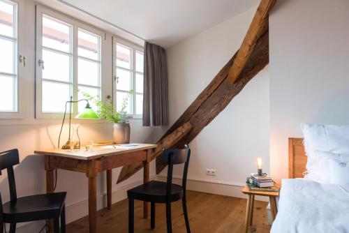 a room with a desk and two chairs and a bed at Palais Wunderlich in Lahr