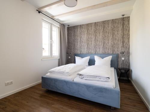 een slaapkamer met een bed met witte lakens en kussens bij Neues Ferienhaus in Kurort Gohrisch