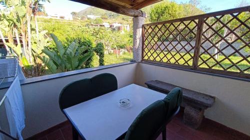 a table and chairs on a balcony with a bench at Residence Villa Cristina in Ischia