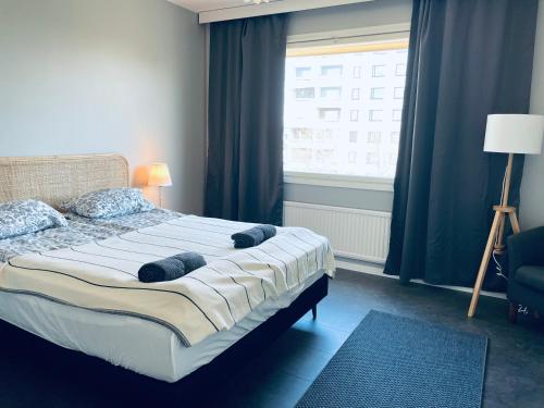 Un dormitorio con una cama grande con ventana. en STAY Matinkatu Apartment, en Espoo