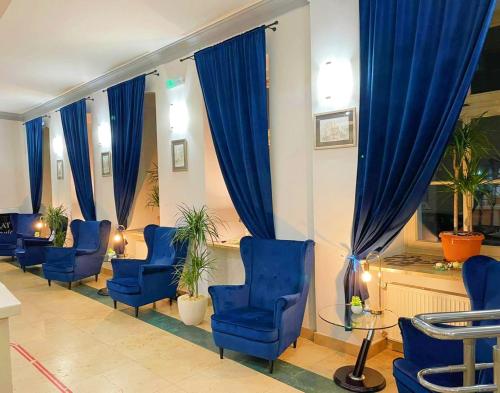 ヴロツワフにあるSchronisko na Wyspieの青い椅子と青いカーテンが備わる待合室