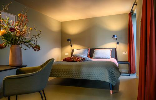 een slaapkamer met een bed en een vaas met bloemen bij B&B Turfkade9 in Franeker