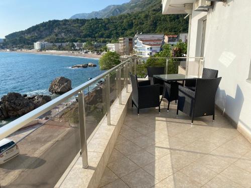 a balcony with a table and chairs overlooking the water at Acacia apartmani Sutomore in Sutomore