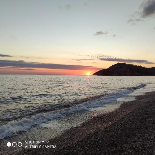 a sunset on a beach with the ocean at Acacia apartmani Sutomore in Sutomore