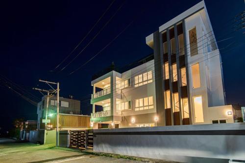 a large white building at night at Olivia Beach Sea and Sky Pool Villa Huahin in Ban Bo Fai (1)