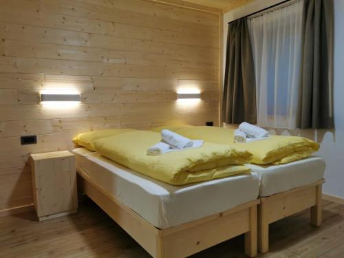 a small bedroom with a bed with yellow sheets at App. Monte Pore - Agriturismo La Majon in Colle Santa Lucia