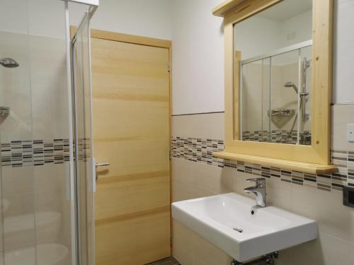 a bathroom with a sink and a shower and a mirror at App. Monte Pore - Agriturismo La Majon in Colle Santa Lucia