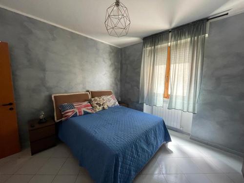 a bedroom with a blue bed and a window at WellHome in Marina di Montemarciano