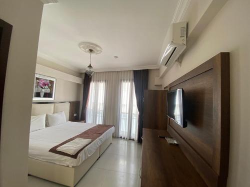 a bedroom with a bed and a flat screen tv at En Kaya Hotel in North Nicosia