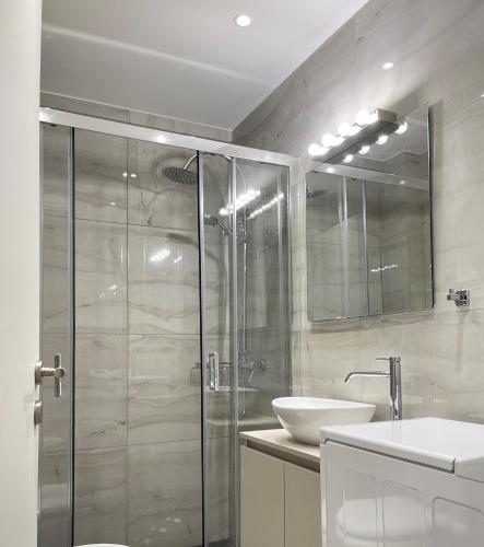 a bathroom with a glass shower and a sink at Athenean Modern Escape near Marina Flisvos in Athens
