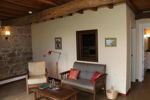 a living room with a couch and a table at Pazo de Chaioso Ribeira Sacra in Maceda