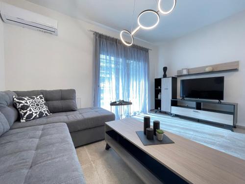 a living room with a couch and a flat screen tv at Athenean Modern Escape near Marina Flisvos in Athens