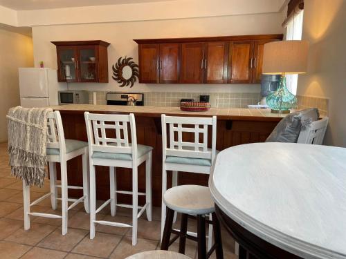 a kitchen with a counter with chairs and a table at Seaside Villas in Caye Caulker