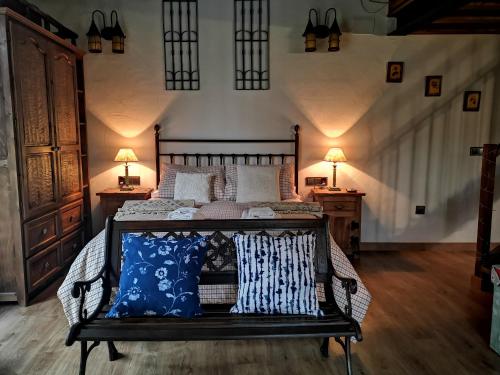 San Martín del PimpollarにあるMolino Navarenasのベッドルーム1室(青と白の枕が備わるベッド1台付)