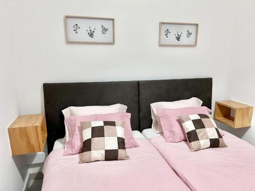 a bedroom with a bed with pink sheets and pillows at Frank's House & Happy BELEM in Lisbon