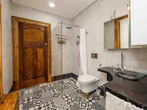 a bathroom with a shower and a toilet and a sink at * Couples and family secluded getaway + pool* in Cape Town