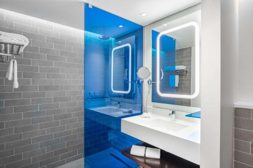 La salle de bains bleue est pourvue de 2 lavabos et d'un miroir. dans l'établissement Park Inn by Radisson Jeddah Madinah Road, à Djeddah