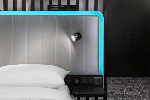 a bed with a blue light on top of it at Park Inn by Radisson Jeddah Madinah Road in Jeddah
