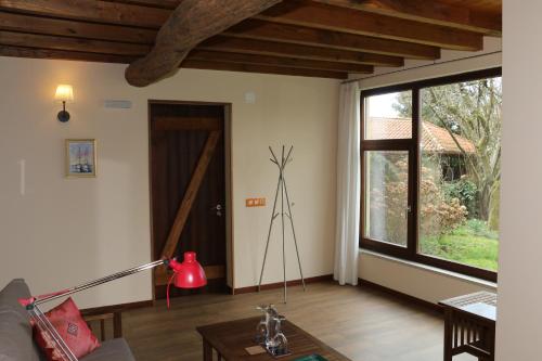 a living room with a couch and a large window at Pazo de Chaioso Ribeira Sacra in Maceda