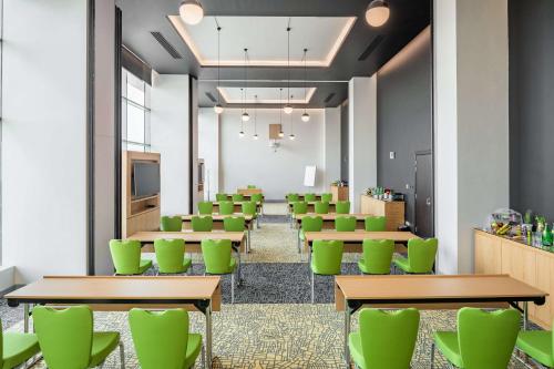 a conference room with green chairs and tables at Park Inn by Radisson Jeddah Madinah Road in Jeddah