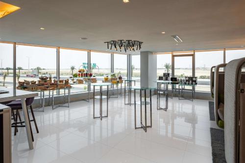 a large room with tables and chairs and windows at Park Inn by Radisson Jeddah Madinah Road in Jeddah