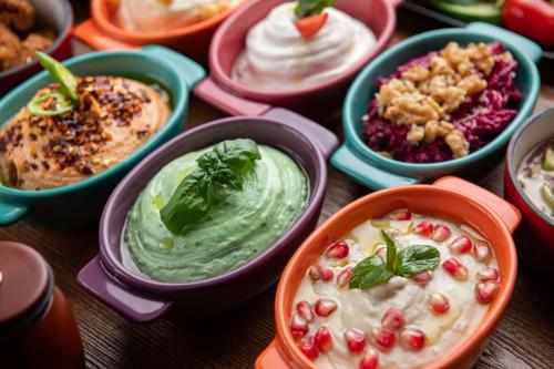 a table topped with bowls of different types of dips at Park Inn by Radisson Jeddah Madinah Road in Jeddah