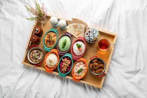 a tray filled with different types of food on a bed at Park Inn by Radisson Jeddah Madinah Road in Jeddah