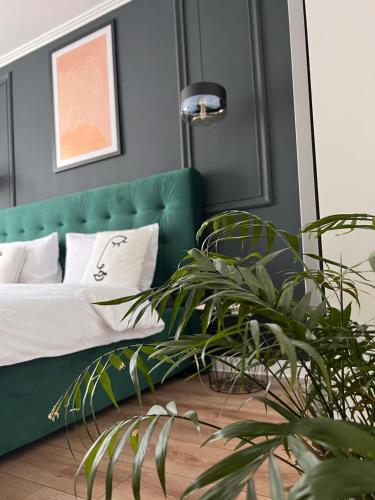 een slaapkamer met een groene bank en een potplant bij Caris Home in Hunedoara