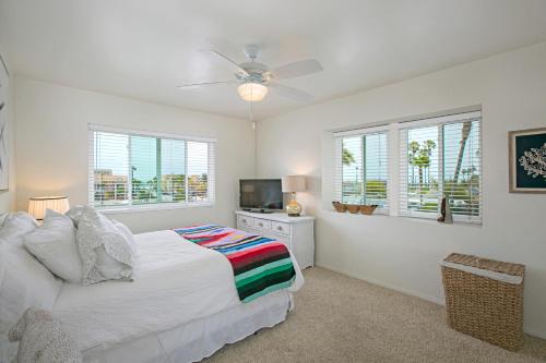 a white bedroom with a bed and a television at South Bay Delight in Imperial Beach