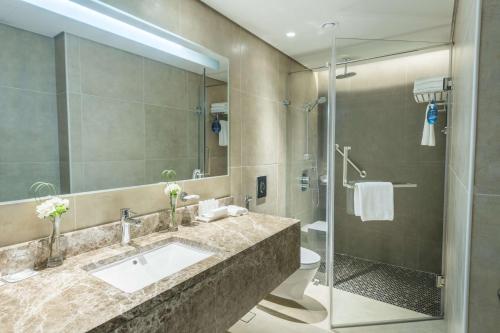 y baño con lavabo y ducha. en Radisson Blu Hotel, Jeddah Corniche en Yeda