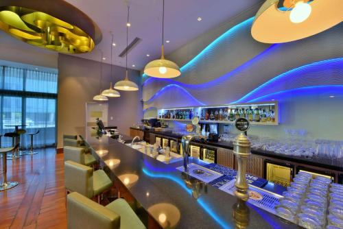 a bar at a restaurant with blue lighting at Radisson Blu Gautrain Hotel, Sandton Johannesburg in Johannesburg