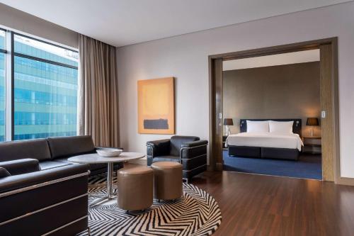 a hotel room with a bed and a living room at Radisson Blu Gautrain Hotel, Sandton Johannesburg in Johannesburg