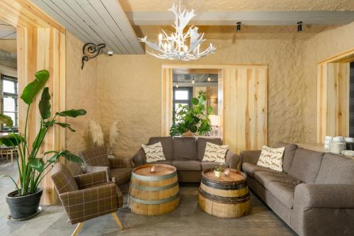 a living room with a couch and chairs and a chandelier at Przystanek Tleń in Tleń