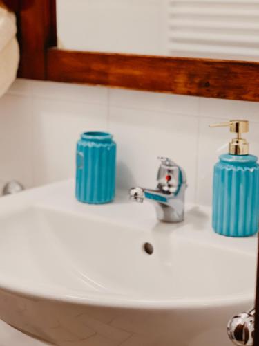 a bathroom sink with two blue candles on it at La Casa di Ele in Sutri