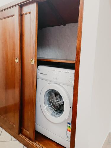 a washer and dryer in a wooden cabinet at La Casa di Ele in Sutri