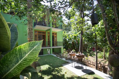 a green house in the middle of a garden at Barefoot Bungalow Hikka in Hikkaduwa