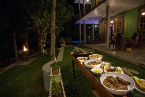 a buffet of food on a table at night at Barefoot Bungalow Hikka in Hikkaduwa