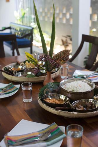 a table with plates of food and plants on it at Barefoot Bungalow Hikka in Hikkaduwa