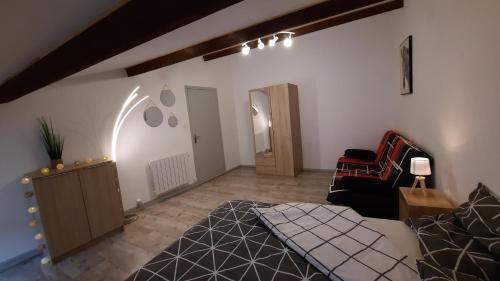 a living room with a bed and a chair at Suite 3 pièces chambre+cuisine+SDB centre ville in Privas